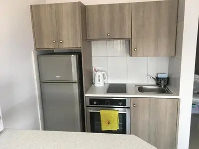 a small kitchen with a refrigerator and a sink at Elena Court Apartments in Ayia Napa