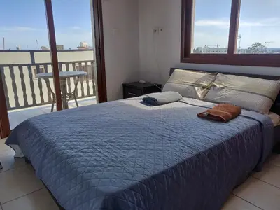 a bedroom with a bed with a view of a balcony at Elena Court Apartments in Ayia Napa