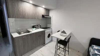 a small kitchen with a sink and a washing machine at Elena Court Apartments in Ayia Napa