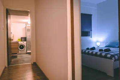 a bedroom with a bed and a kitchen with a microwave at Cozy Flat City Center in Nicosia