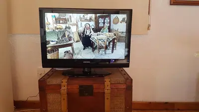a television sitting on top of a wooden chest at ZORBAS Sea View No 4 in Larnaka