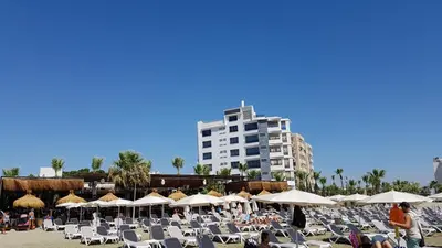 a beach with chairs and umbrellas and a building at ZORBAS Sea View No 4 in Larnaka