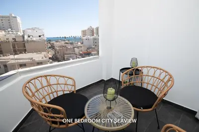 two chairs and a table on a balcony with a view at Lazuli City & Seaview Apartments in Larnaka