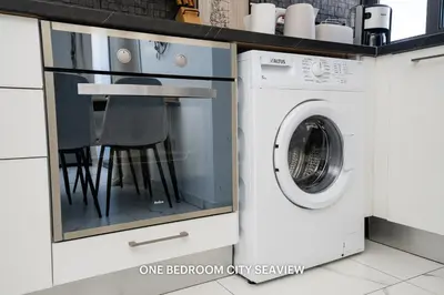 a white washer and dryer next to a washing machine at Lazuli City & Seaview Apartments in Larnaka