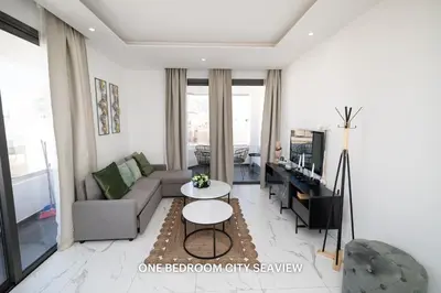 a living room with a couch and a table at Lazuli City & Seaview Apartments in Larnaka