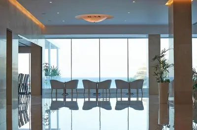 a dining room with glass walls and a table and chairs at Sunrise Beach Hotel in Protaras