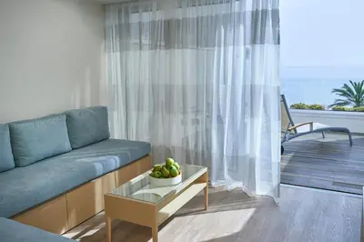 a living room with a couch and a table with a bowl of fruit at Sunrise Beach Hotel in Protaras