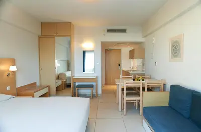 a living room with a couch and a dining room at Sunrise Oasis Hotel & Waterpark in Protaras