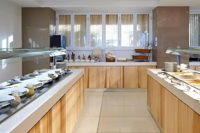 a large kitchen with wooden cabinets and a stove at Sunrise Oasis Hotel & Waterpark in Protaras