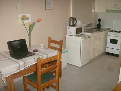 a kitchen with a table with a laptop on it at Rantzo Holiday Apartments in Pissouri