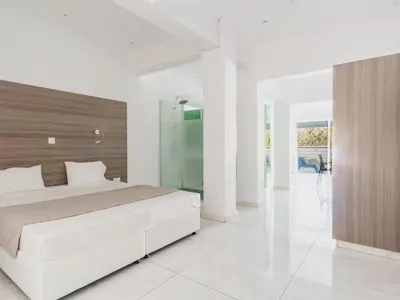 a white bedroom with a large bed and a glass door at Rio Gardens Aparthotel in Ayia Napa