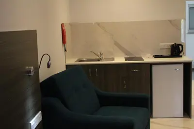 a living room with a green chair and a sink at Rio Gardens Aparthotel in Ayia Napa