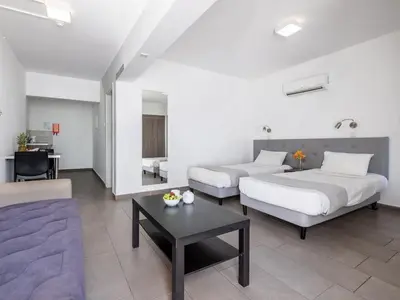 a hotel room with two beds and a couch at Rio Gardens Aparthotel in Ayia Napa