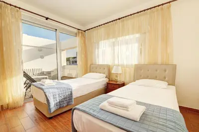 a hotel room with two beds and a balcony at Seafront Protaras Apartments in Protaras