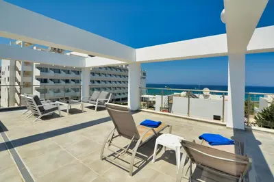 a balcony with chairs and a view of the ocean at Seafront Protaras Apartments in Protaras