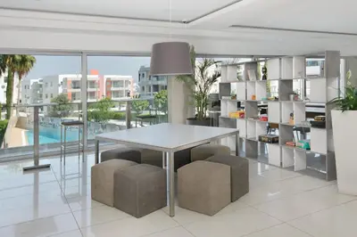a dining room with a white table and stools at UC Hall Residence in Nicosia