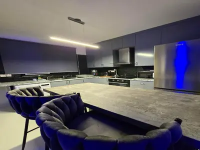 a kitchen with a table and some blue chairs at 3 Bedroom Villa, private pool, hot tub in Protaras