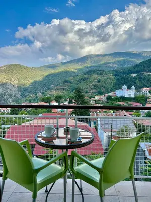 a table and chairs on a balcony with a view at Two Flowers Hotel in Pedoulas