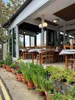 a restaurant with tables and chairs and potted plants at Two Flowers Hotel in Pedoulas