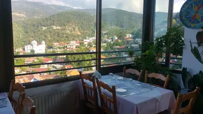 a table in a restaurant with a view of a city at Two Flowers Hotel in Pedoulas