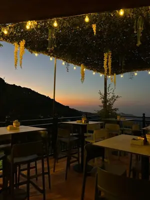 a restaurant with tables and chairs and lights at Two Flowers Hotel in Pedoulas