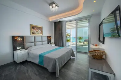 a bedroom with a bed and a view of the ocean at Sunprime Protaras Beach - Adults Only in Protaras