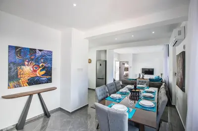 a dining room and living room with a painting on the wall at Marimar villa in Protaras