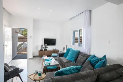 a living room with a couch and blue pillows at Marimar villa in Protaras