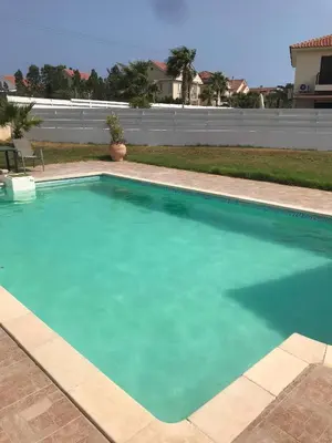 a large pool with blue water in a yard at Limni Pool House B in Larnaka