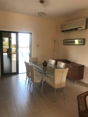 a dining room with a glass table and chairs at Limni Pool House B in Larnaka