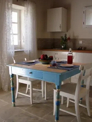 a blue table in a kitchen with two chairs and a table at Dolphin Guest House and Studios in Tochni