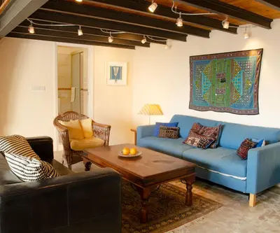 a living room with a blue couch and a table at Dolphin Guest House and Studios in Tochni