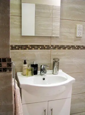 a bathroom with a white sink and a mirror at Dolphin Guest House and Studios in Tochni