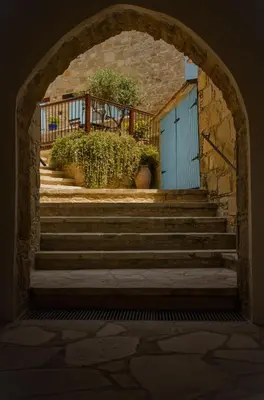 an archway with a blue door and stairs at Dolphin Guest House and Studios in Tochni