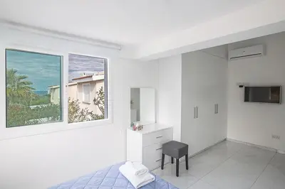 a white bedroom with a bed and a window at Konnos Hight Villa in Protaras