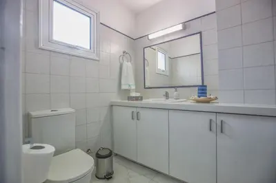 a bathroom with a toilet and a sink and a mirror at Konnos Hight Villa in Protaras