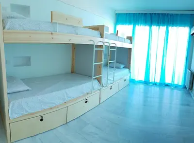 two bunk beds in a room with blue curtains at NEX Hostel in Nicosia