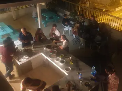 a group of people sitting around a table on a balcony at NEX Hostel in Nicosia