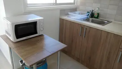 a small kitchen with a microwave and a sink at LCA4 flat for you apartment in Larnaka