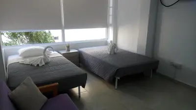 a small bedroom with two beds and a window at LCA4 flat for you apartment in Larnaka