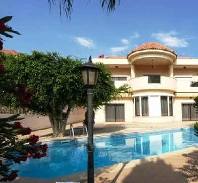 a house with a light pole in front of a swimming pool at Patatas Villa in Limassol