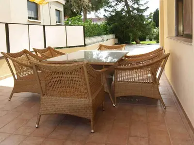 a wicker table and chairs on a patio at Patatas Villa in Limassol