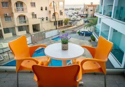 a table and chairs on a balcony with a table at A Maos Hotel Apartments in Ayia Napa