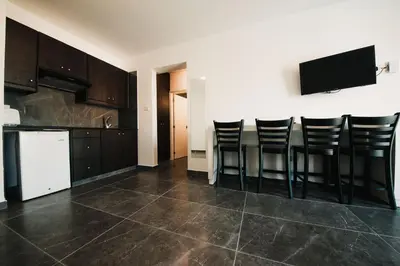 a kitchen with black cabinets and a bar with stools at A Maos Hotel Apartments in Ayia Napa