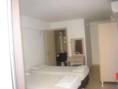 a bedroom with two beds and a mirror at A Maos Hotel Apartments in Ayia Napa