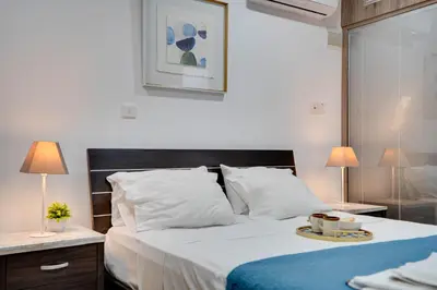 a bedroom with a bed with a tray of food on it at Atlantis Apartments 50m from Makenzy seafront in Larnaka
