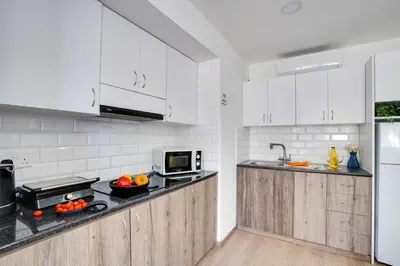 a kitchen with white cabinets and a counter top at Atlantis Apartments 50m from Makenzy seafront in Larnaka