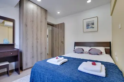 a bedroom with a blue bed with towels on it at Atlantis Apartments 50m from Makenzy seafront in Larnaka