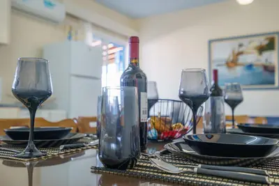 a table with wine glasses and plates on it at The Blue Mile w Jacuzzi in Paralimni