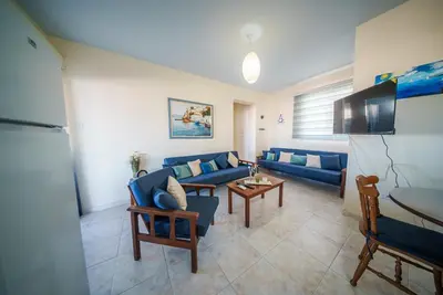a living room with a blue couch and a table at The Blue Mile w Jacuzzi in Paralimni